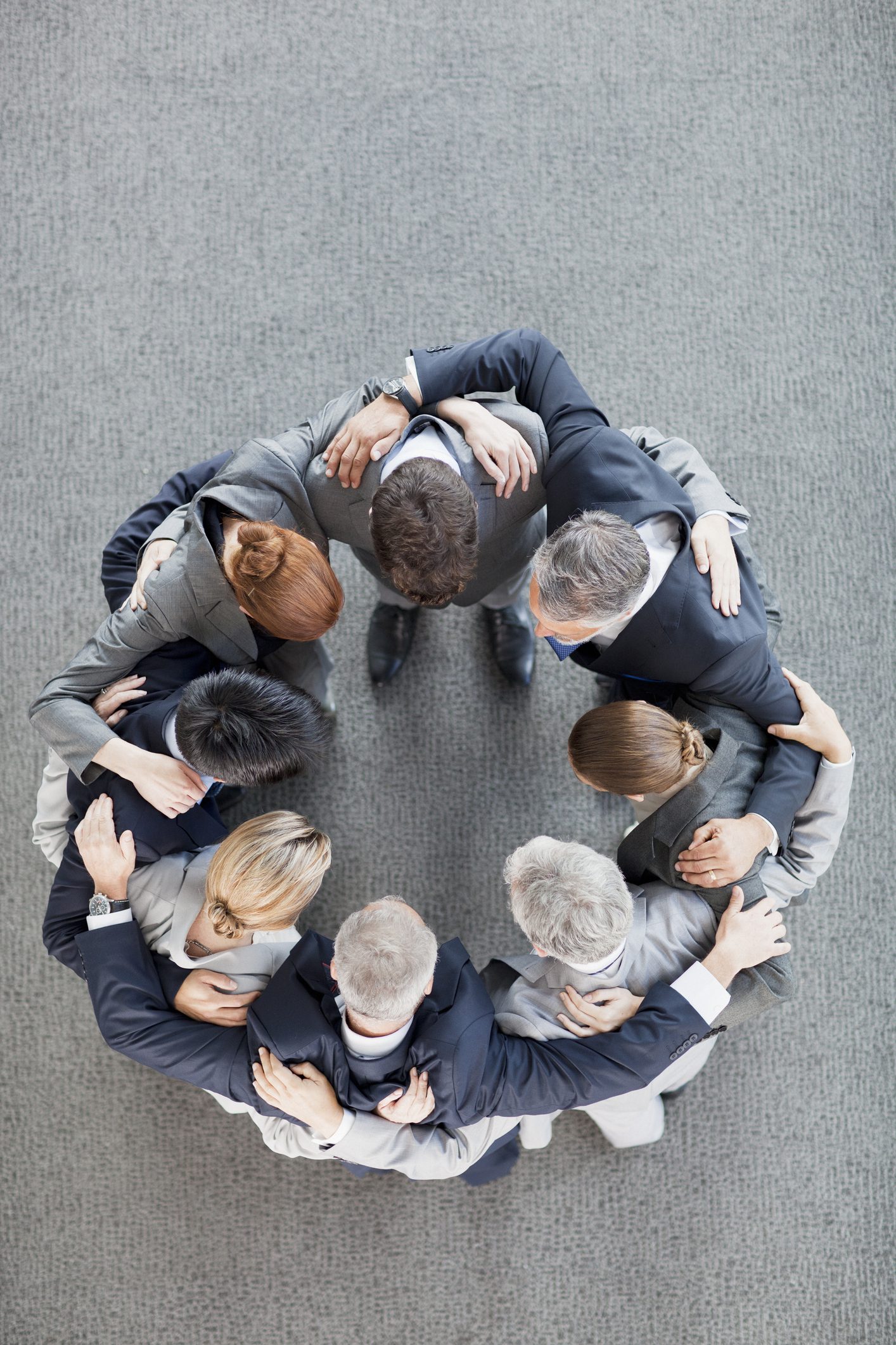 Group of people in a huddle circle.